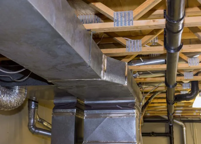 Exposed metal HVAC ductwork installed in a building under construction, showing ventilation system components.
